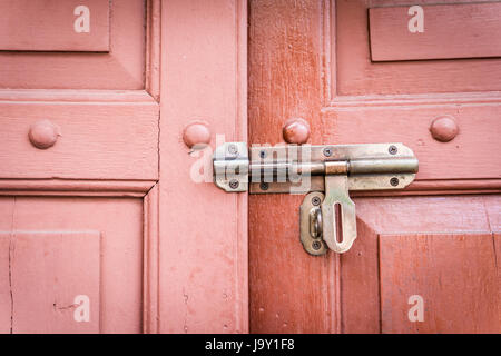 old bolt on a retro wooden door is unlock. Stock Photo