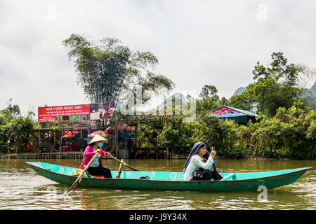 Tourist on Perfume Pagoda trip making their way to famous caves and temples in boats along Yen Vy river in North Vietnam Stock Photo