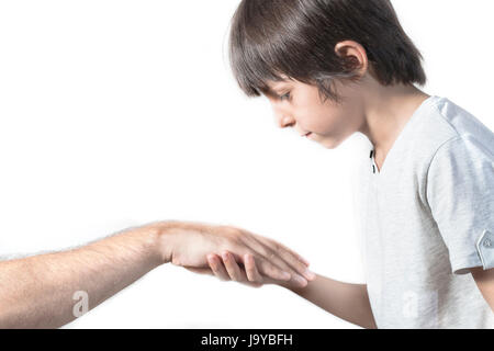 Kid kissing parent's hand for traditional act of respect Stock Photo