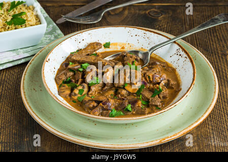 Beef and mushroom Strogonoff with rice on wooden table Stock Photo