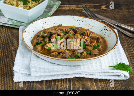 Beef and mushroom Strogonoff with rice on wooden table Stock Photo