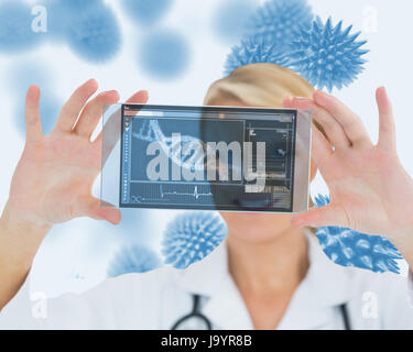Blonde nurse holding a virtual screen in front of camera Stock Photo