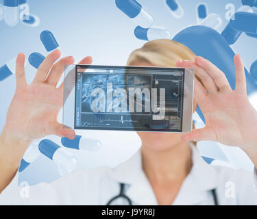 Cheerful blonde nurse holding a virtual screen in front of camera Stock Photo