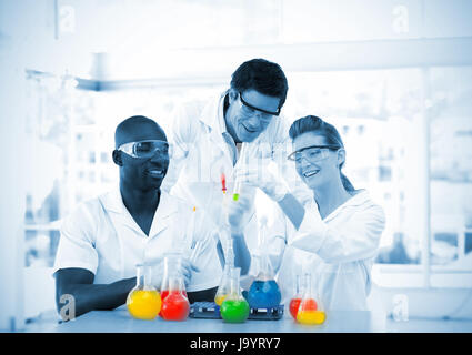 Group of smiling scientists examining testtubes in a laboratory Stock Photo
