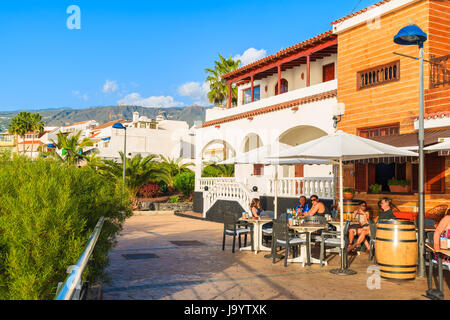 LA CALETA, TENERIFE ISLAND - NOV 16, 2015: people sitting in restaurant on coastal promenade in La Caleta town on southern Tenerife, Canary Islands, S Stock Photo