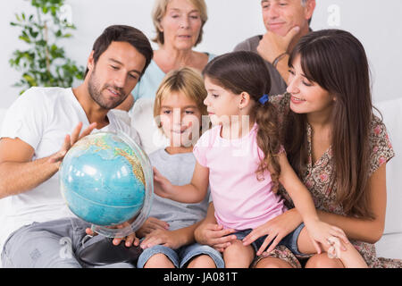 Happy family looking at globe on the couch Stock Photo