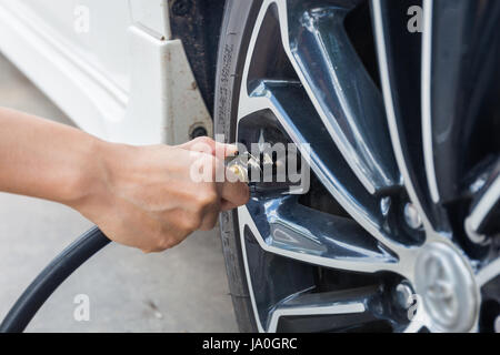 Man checking air pressure and filling air in the tires of car. Concept picture Stock Photo