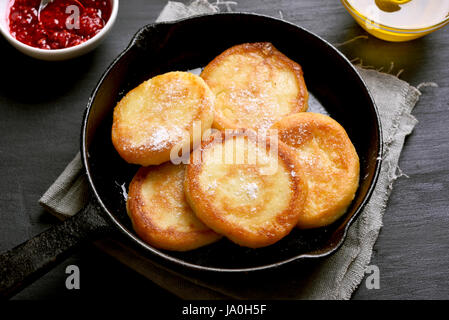 Fried curd cheese pancakes in frying pan, close up view Stock Photo