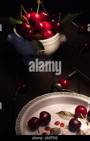 Still life with fresh ripe cherries on black wood background. Stock Photo