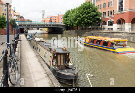 Bristol, England - July 17, 2016: A city ferryboat passes office buildings and narrowboats on Temple Quay in Bristol's Floating Harbour. Stock Photo