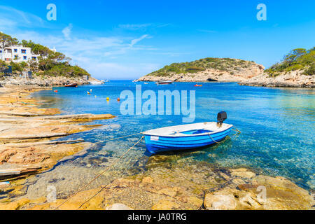 Small fishing boat on shore Cala Portinatx bay, Ibiza island, Spain Stock Photo