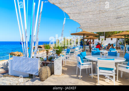 IBIZA ISLAND, SPAIN - MAY 20, 2017: Tables in Cala Nova beach restaurant and sea view, Ibiza island, Spain. Stock Photo