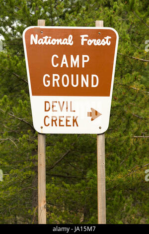 A metal sign along the highway points the way to Devil Creek Campground Stock Photo