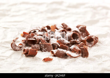 Chocolate curls sprinkled with powdered sugar - closeup Stock Photo