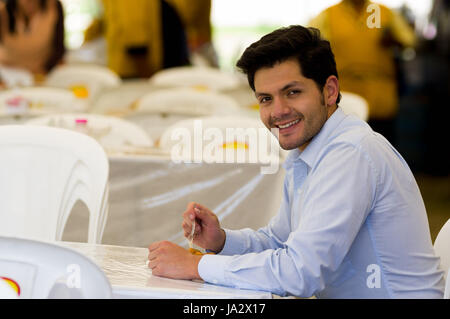 Handsome young businessman eating a homemade fritters with sugar and its ingredients Stock Photo