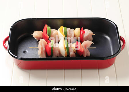 Raw chicken shish kebabs in a roasting pan Stock Photo