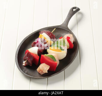 Raw shish kebabs on cast iron platter Stock Photo