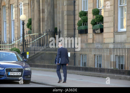 Businessman in suit walking on the street Glasgow Stock Photo