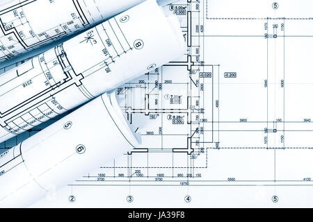 rolls of drawing paper with architectural project plans on blueprint background Stock Photo