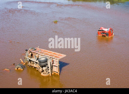 the broken truck lies in dirty water Stock Photo