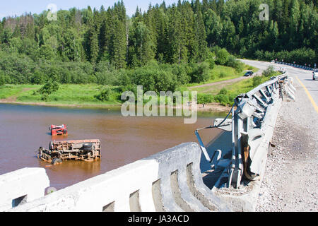 the broken truck lies in dirty water Stock Photo