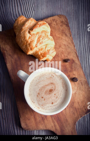 Coffee with croissant for breakfast. Cappuccino coffee, tint image with copy space. Stock Photo