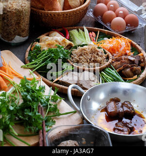 Famous Vietnamese food is banh mi thit, popular street food from bread stuffed with raw material: pork, ham, pate, egg, scallions, carrot, cucumber.. Stock Photo