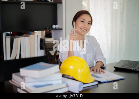 Female engineers are thinking to create new jobs and are smiling and working happy Stock Photo