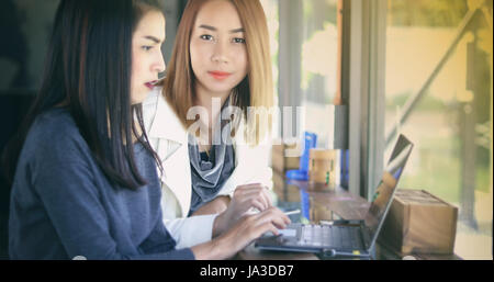 Two Asian business women using notebook working and Discussion of the important contract at office Stock Photo
