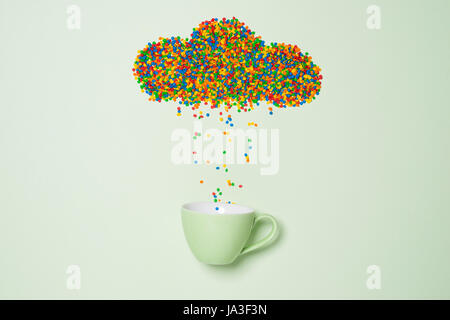 Candies in shape of rainy cloud on green background. Weather concept. Stock Photo