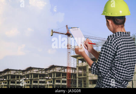 women asian engineer inspecting and working and holding blueprints at construction site Stock Photo