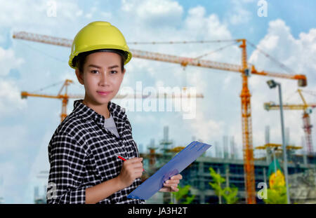 Asian women engineers and technicians are checking the list on the board at construction site Stock Photo