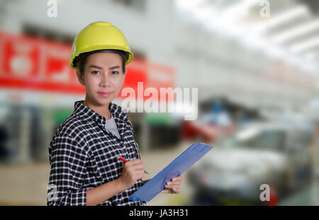 Asian women engineers and technicians mechanic  are checking and inspectingthe list on the board  of a car in auto repair shop Stock Photo