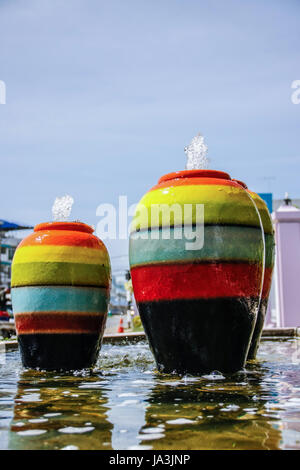 colorful jar pot fountain in pond front of entrance door Stock Photo