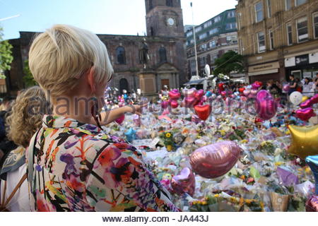 Two women gaze at the floral tribute in St Ann's Square to the victims of the Manchester bombing.Credit; Reallifephotos/Alamy Stock Photo