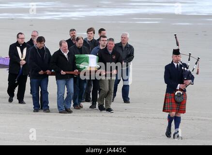The coffin of Eilidh MacLeod draped in the Barra flag is carried across Traigh Mhor beach at Barra airport after it arrived by chartered plane. The body of the Manchester bomb victim was flown home to the devastated community on the island of Barra ahead of her funeral. Stock Photo