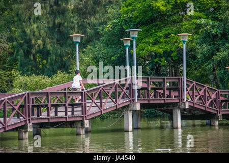 red wooden bridge over pond on park of silpakorn university, Nakhonpathom Stock Photo