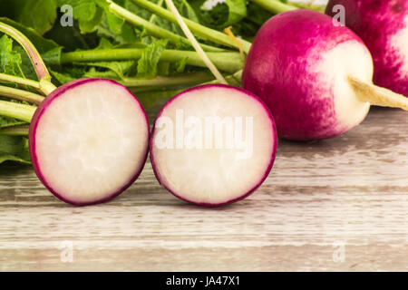 Juicy fresh radish in a cut on a white wooden background close up Stock Photo