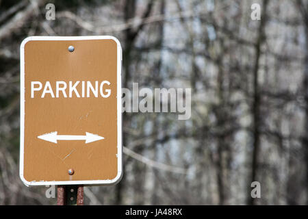 brown parking sign with arrows pointing in both directions with copy space Stock Photo