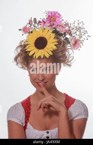Portrait of a young woman with hairpin and summer flowers in her hair and Bavarian dirndl Stock Photo