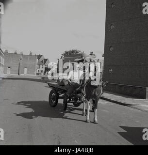 1971, historical, two male totters or rag-and-bone men on their horse and cart in an empty street in South London, as they do their rounds looking for scrap metal and other unwanted household items. Stock Photo