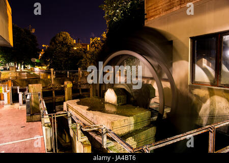 Fabulous water mill in the center of the city at night. Old architecture. Stock Photo