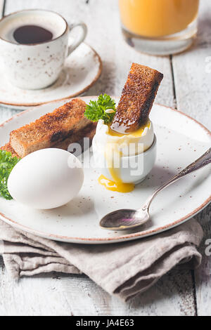 delicious breakfast with soft boiled eggs and crispy toasts on wooden table Stock Photo