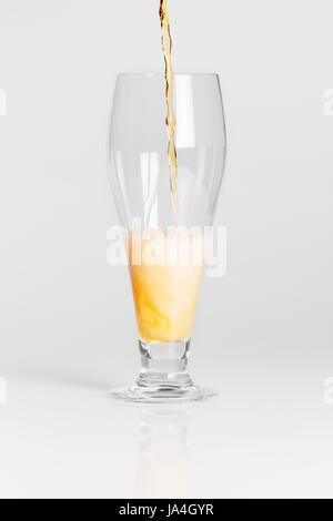 Lager beer pouring into glass from bottle isolated on white background Stock Photo