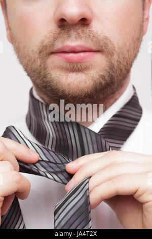 Young businessman adjust necktie to his suit Stock Photo