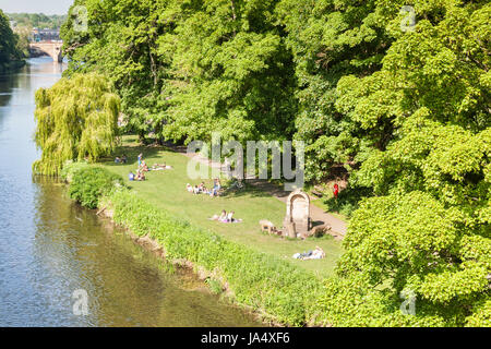 25 May 2017: Durham City, County Durham, England, UK - people relaxing on the grass on the banks of the River Wear. Stock Photo