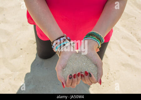 Hands forming heart shape full of white sand. Stock Photo
