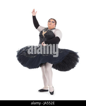 Overweight drag queen dancing in a tutu nimbly balancing on tiptoe with his foot raised in a fun caricature of a female ballet dancer, on white Stock Photo