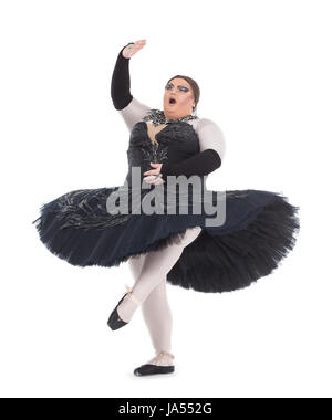 Overweight drag queen dancing in a tutu nimbly balancing on tiptoe with his foot raised in a fun caricature of a female ballet dancer, on white Stock Photo