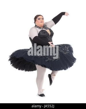 Overweight drag queen dancing in a tutu nimbly balancing on tiptoe with his foot raised in a fun caricature of a female ballet dancer, on white Stock Photo